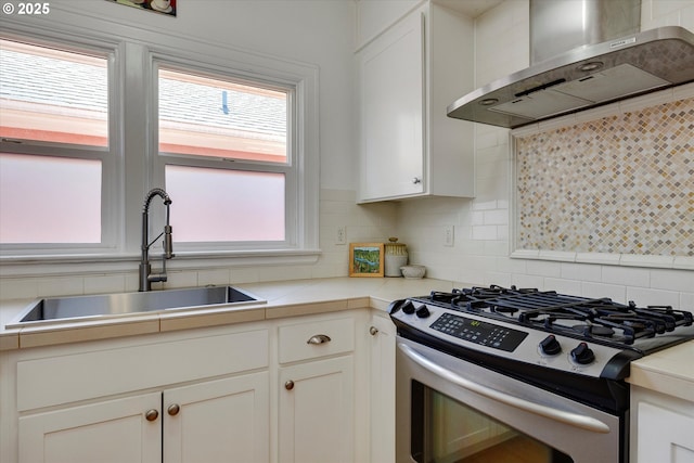 1534 NE 26th Ave Unit 8, Portland, OR 97232 - kitchen featuring gas stove, wall chimney exhaust hood, a sink, and plenty of natural light