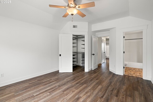 unfurnished bedroom with baseboards, lofted ceiling, wood finished floors, and visible vents