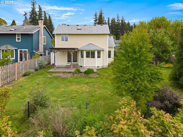 rear view of property with a lawn, a pergola, a fenced backyard, and a patio area