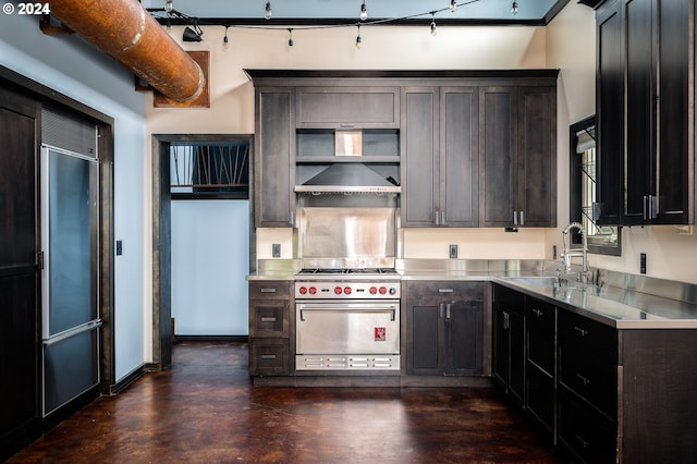 kitchen with stainless steel counters, high end stainless steel range, dark brown cabinets, and sink