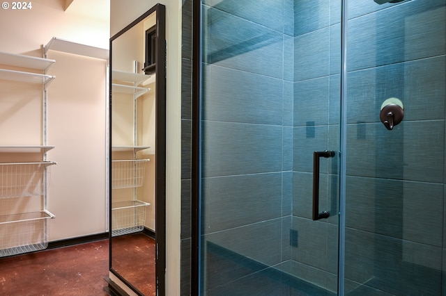 bathroom with a shower with door and concrete flooring