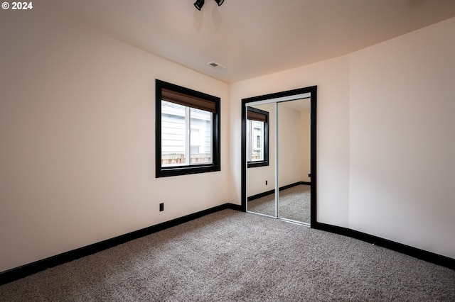 unfurnished bedroom with carpet floors and a closet