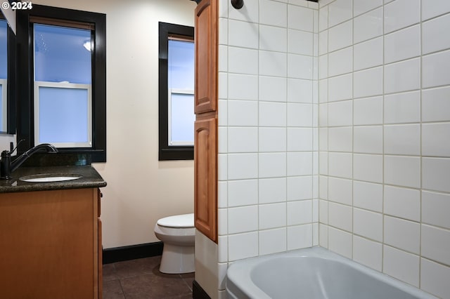 full bathroom with tiled shower / bath, tile patterned flooring, vanity, and toilet