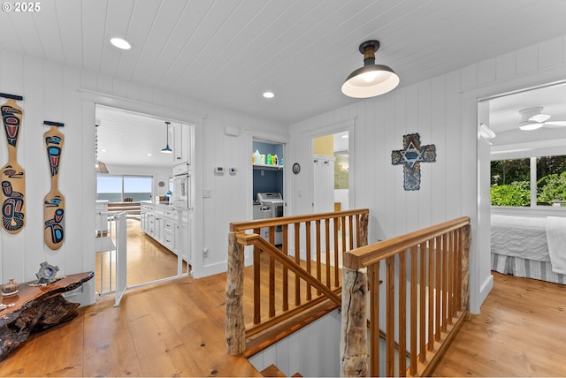 15436 Oceanview Dr, Brookings, OR 97415 - hallway featuring light wood finished floors, independent washer and dryer, plenty of natural light, and an upstairs landing