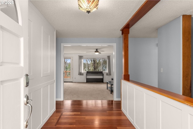 hallway with hardwood / wood-style flooring and a textured ceiling