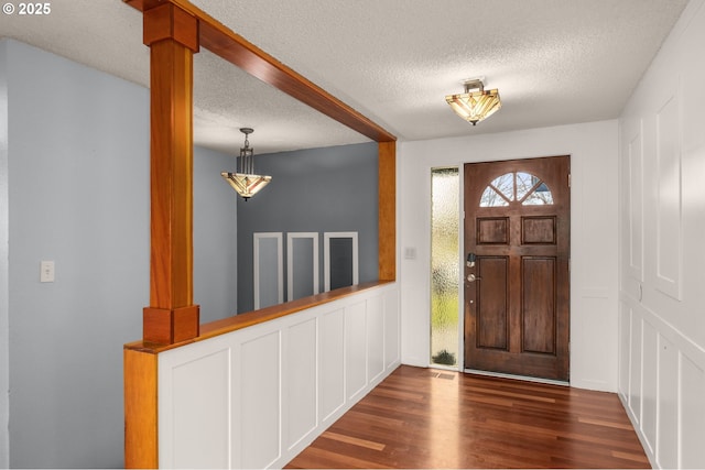 foyer featuring dark hardwood / wood-style floors and a textured ceiling