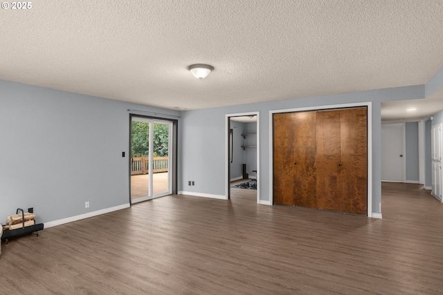 unfurnished bedroom with dark hardwood / wood-style flooring, access to outside, and a textured ceiling