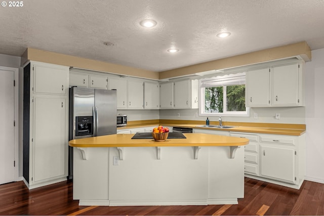 kitchen featuring a kitchen bar, a center island, and sink