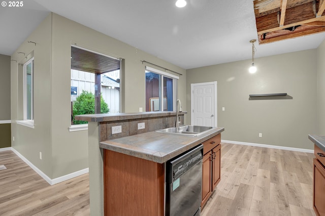 kitchen featuring dishwasher, sink, an island with sink, light hardwood / wood-style floors, and pendant lighting