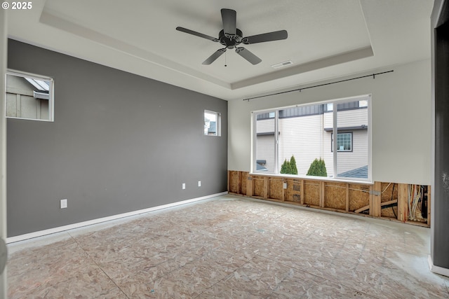 unfurnished room featuring a raised ceiling and ceiling fan