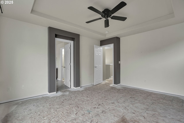 unfurnished bedroom with a tray ceiling and ceiling fan