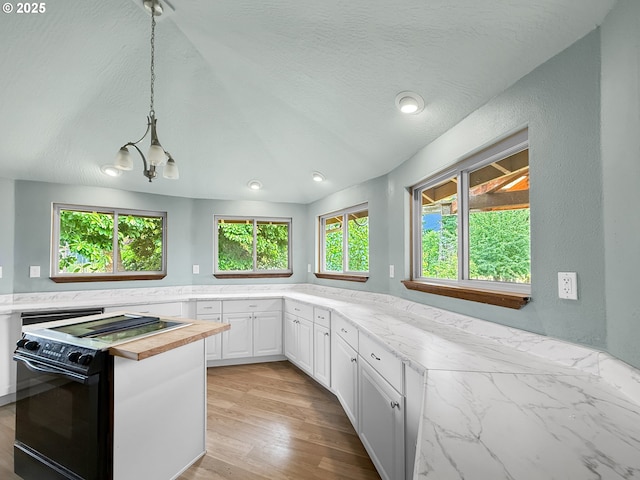 55 Irving St, Cathlamet, WA 98612 - kitchen with black electric range, a chandelier, white cabinets, decorative light fixtures, and light wood-style floors