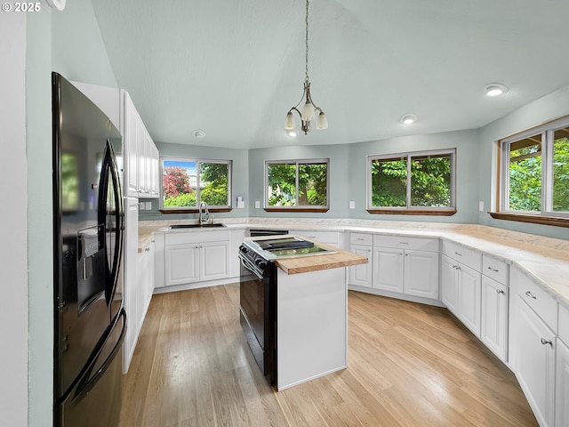 55 Irving St, Cathlamet, WA 98612 - kitchen with black appliances, healthy amount of natural light, light wood-style floors, and white cabinetry