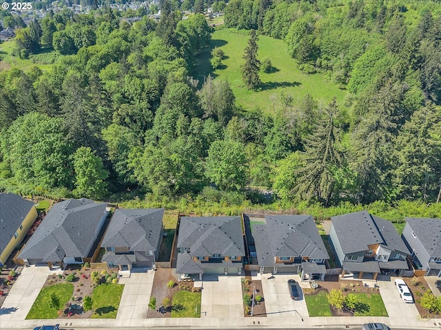aerial view of property's location with nearby suburban area and a heavily wooded area