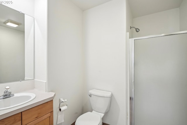 bathroom featuring an enclosed shower, toilet, and vanity