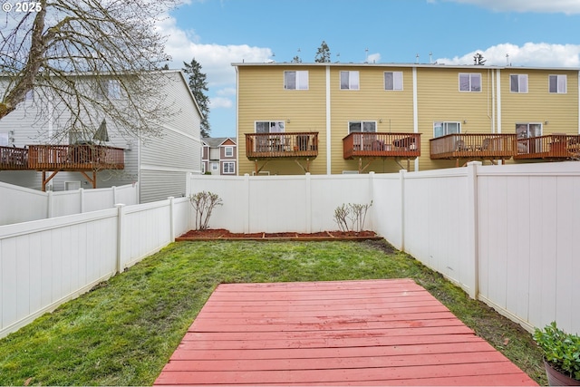 wooden terrace featuring a lawn and a fenced backyard