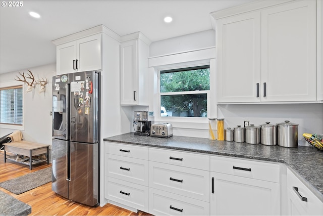 kitchen with light wood finished floors, stainless steel refrigerator with ice dispenser, white cabinetry, and recessed lighting