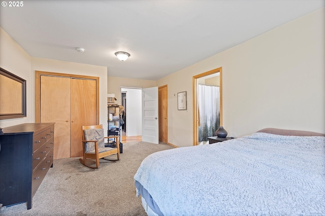 bedroom with a closet, light colored carpet, and baseboards