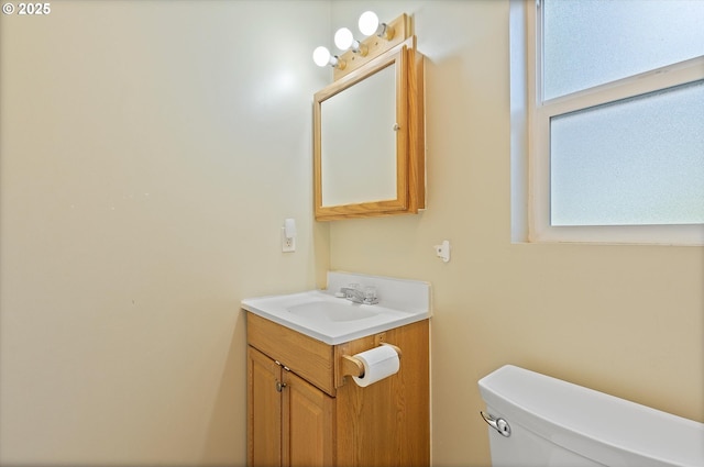 bathroom featuring plenty of natural light, vanity, and toilet