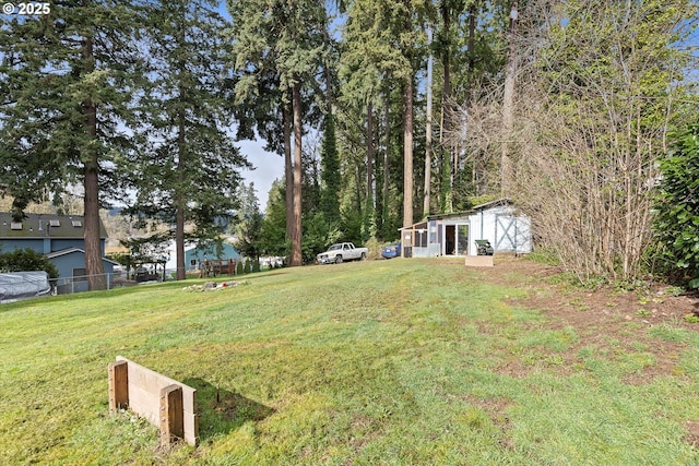 view of yard featuring an outbuilding and fence