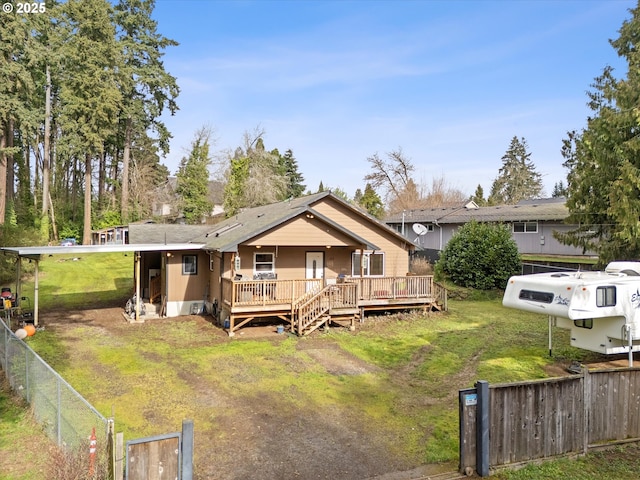 back of house with a lawn, a wooden deck, and fence