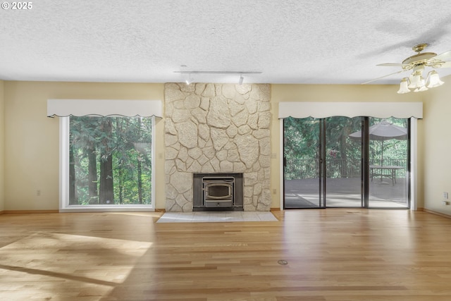 17002 NE 50th Ave, Vancouver, WA 98686 - unfurnished living room with rail lighting, a textured ceiling, wood finished floors, ceiling fan, and a wood stove