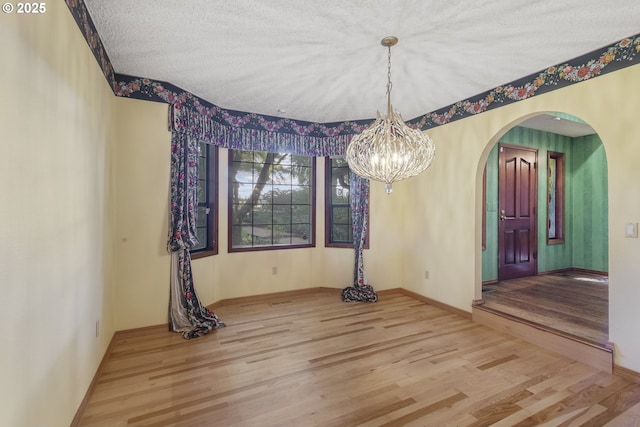 17002 NE 50th Ave, Vancouver, WA 98686 - unfurnished dining area with arched walkways, wood finished floors, a chandelier, baseboards, and a textured ceiling