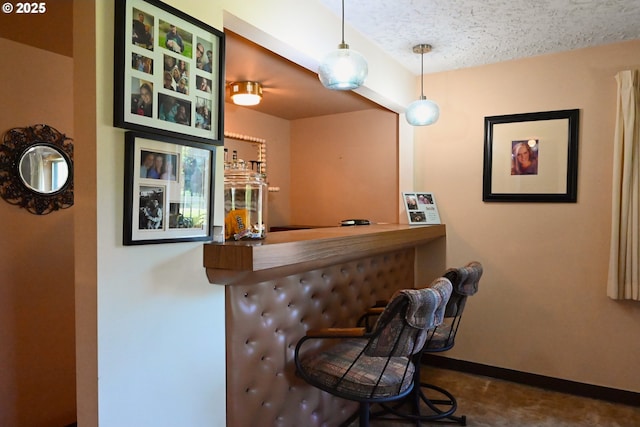 7811 NE 78th St, Vancouver, WA 98662 - bar with decorative light fixtures, a textured ceiling, a bar, and baseboards