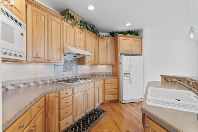 301 Chinook St, Molalla, OR 97038 - kitchen with white appliances, under cabinet range hood, a sink, light wood-style floors, and light brown cabinetry