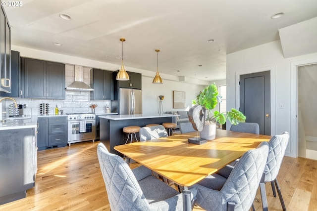 dining space with light wood-type flooring and recessed lighting