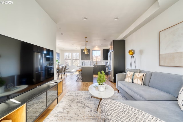 living room with light wood-style flooring and recessed lighting