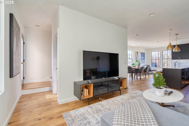 living area with light wood-style floors, recessed lighting, and baseboards