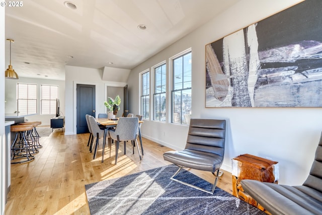 dining area with light wood finished floors and baseboards