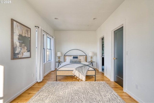 bedroom with light wood-type flooring and baseboards