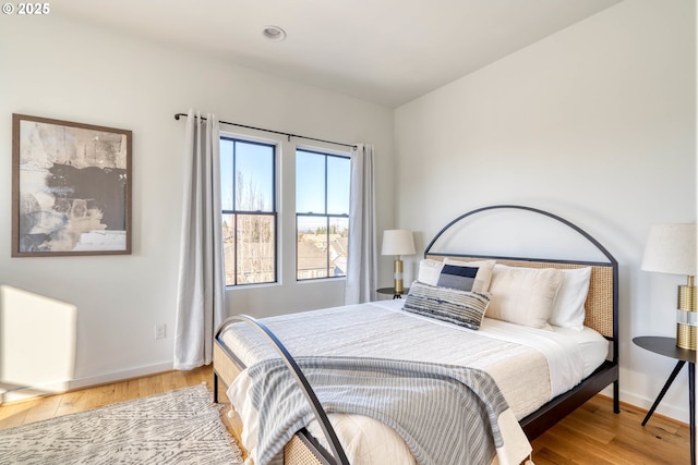 bedroom with light wood-type flooring and baseboards