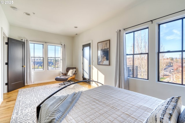 bedroom with light wood finished floors and multiple windows