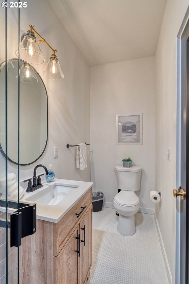 bathroom with toilet, tile patterned floors, vanity, and baseboards