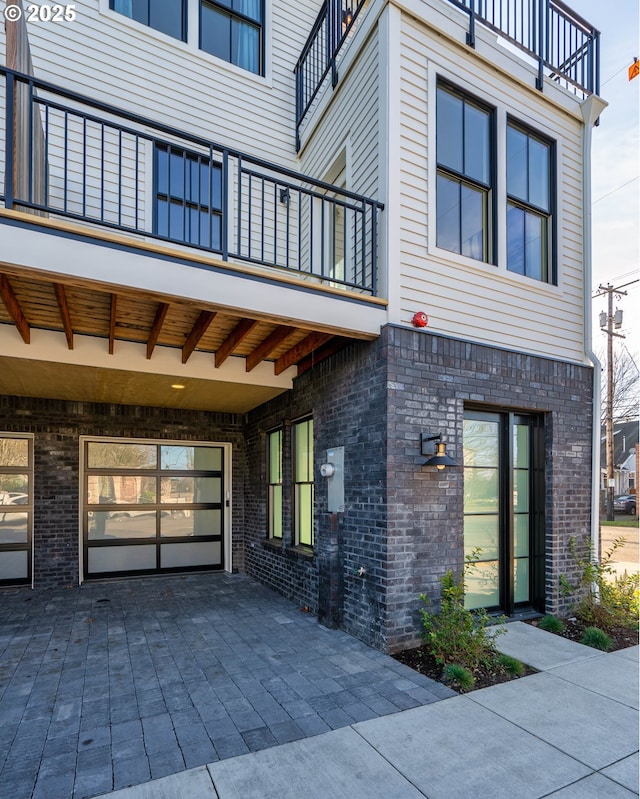 exterior space featuring a balcony and brick siding