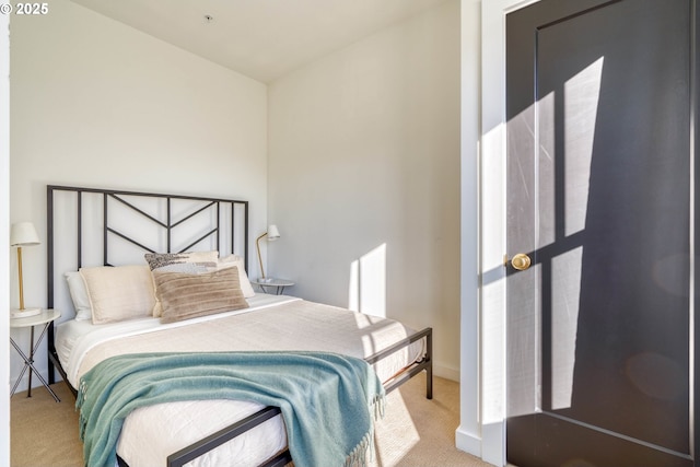 bedroom featuring light carpet and baseboards