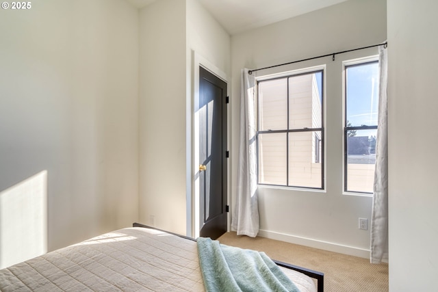 bedroom featuring baseboards and light colored carpet