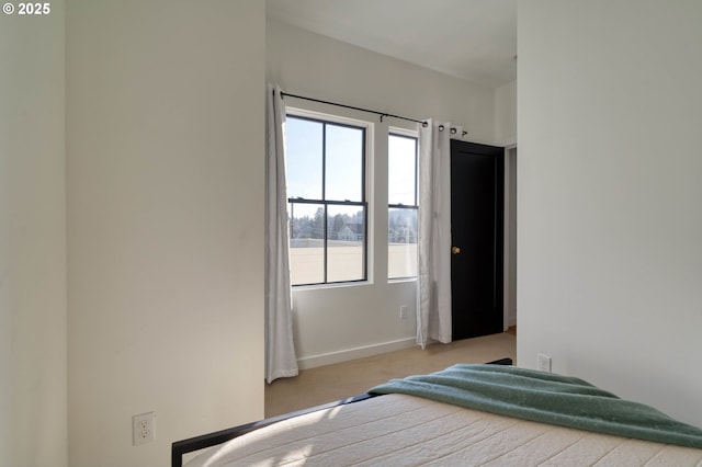 bedroom with baseboards and light colored carpet