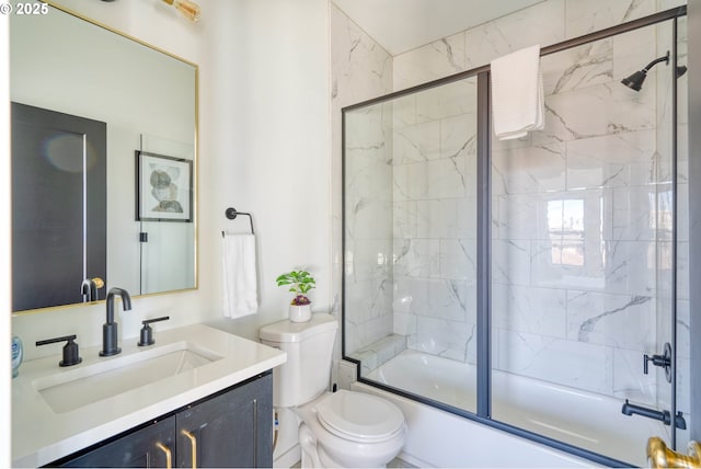 bathroom with enclosed tub / shower combo, vanity, and toilet