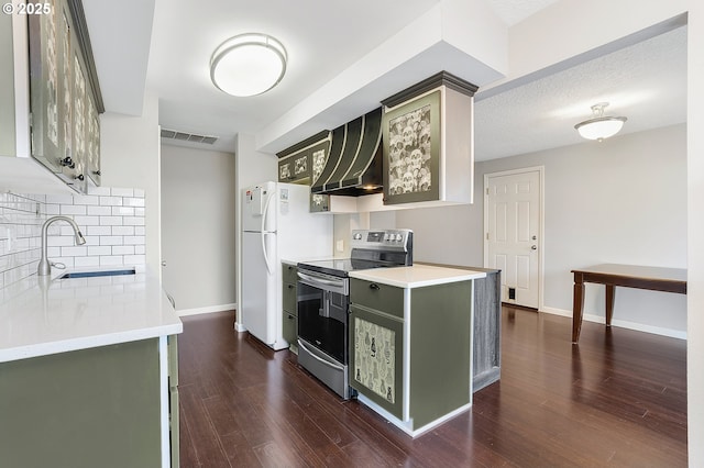 kitchen featuring visible vents, a sink, wall chimney range hood, stainless steel electric range oven, and green cabinetry