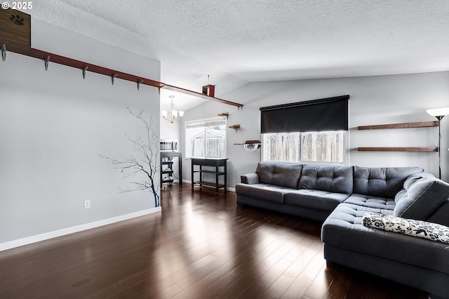 living room featuring vaulted ceiling, a textured ceiling, an inviting chandelier, and wood finished floors