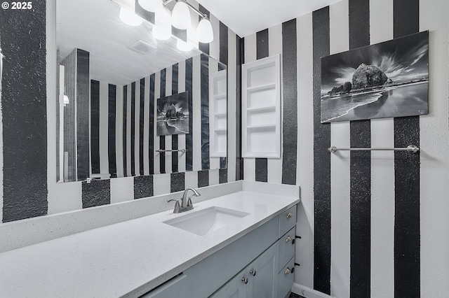 bathroom with vanity and wallpapered walls