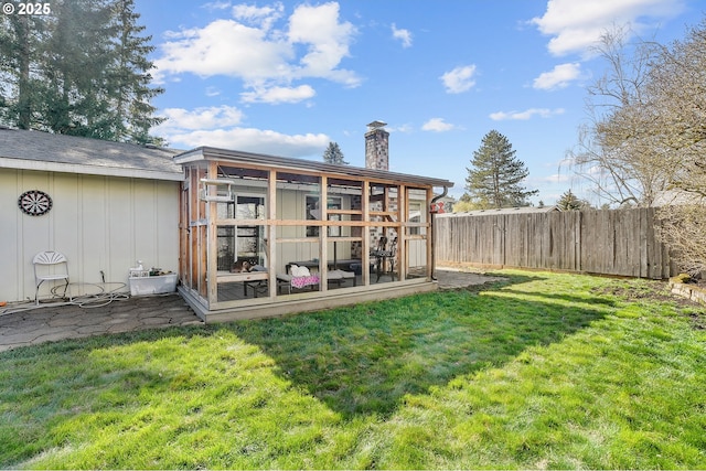 rear view of house featuring board and batten siding, fence, a lawn, exterior structure, and an outbuilding