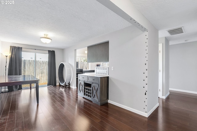 interior space featuring baseboards, visible vents, and dark wood-style flooring