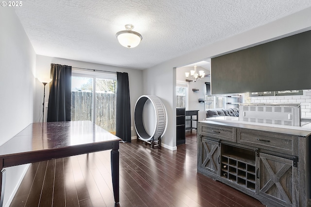 home office featuring baseboards, a notable chandelier, dark wood-style floors, and a textured ceiling