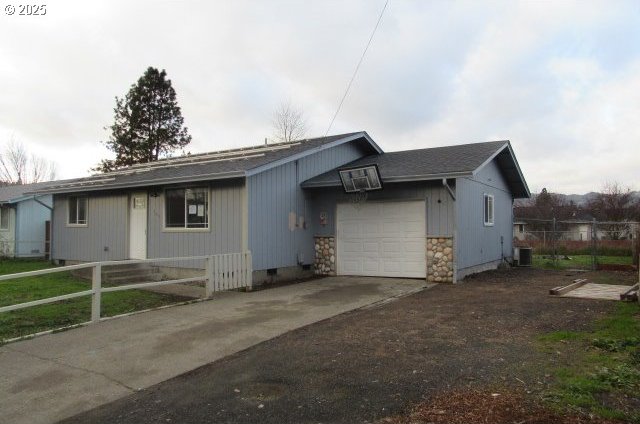 ranch-style home featuring a garage and central AC