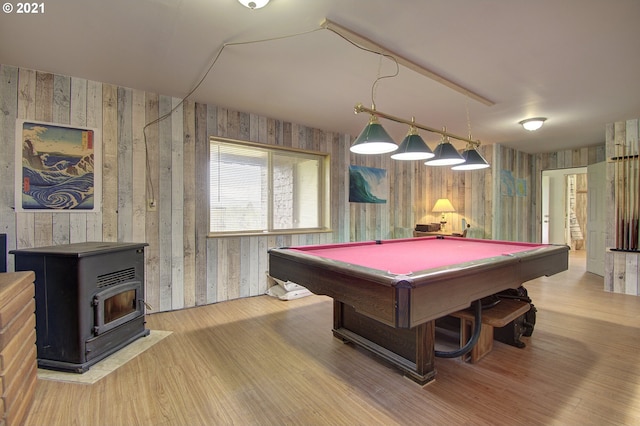 recreation room with billiards, wood finished floors, and a wood stove